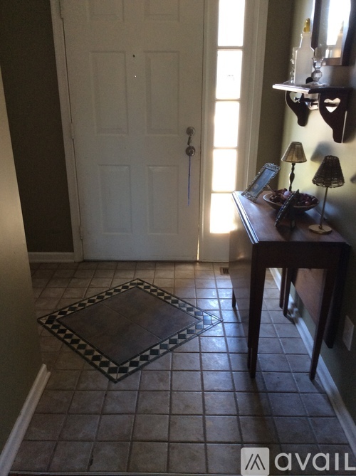 A white door is in a room with a black and white tile floor.