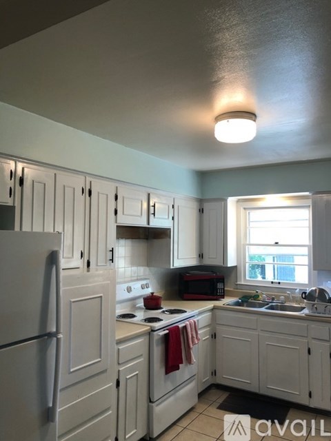 A kitchen with white cabinets and appliances.