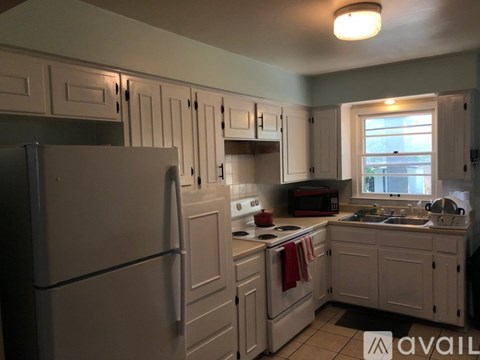 A kitchen with white cabinets and a refrigerator.