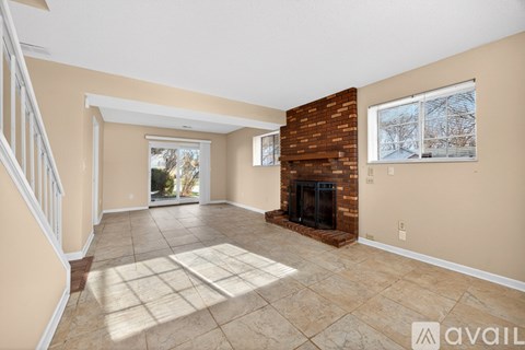 A living room with a fireplace and a rug on the floor.