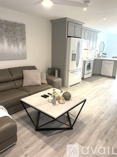 A modern living room with a brown leather couch and a white coffee table.