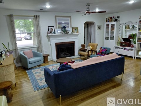 A living room with a blue couch and a fireplace.