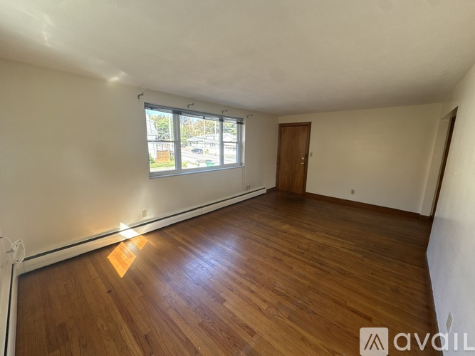 A room with wooden flooring and a window.