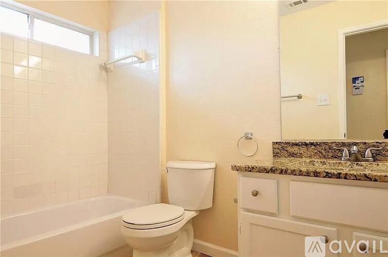 A bathroom with a toilet, sink, and bathtub.
