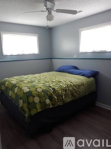 A bedroom with a bed and a ceiling fan.