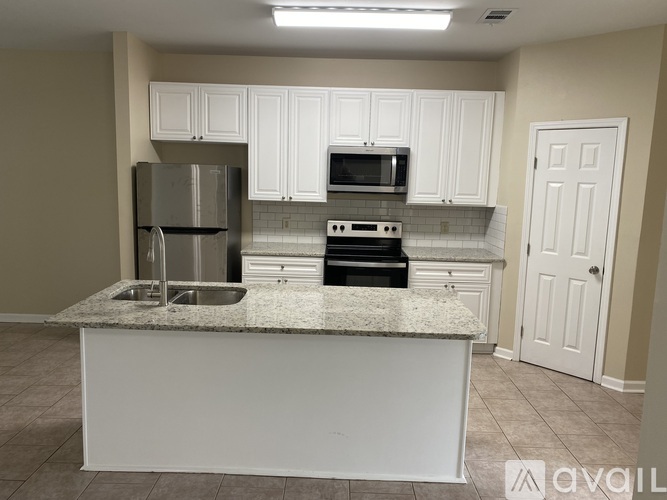 A kitchen with white cabinets and a granite countertop.