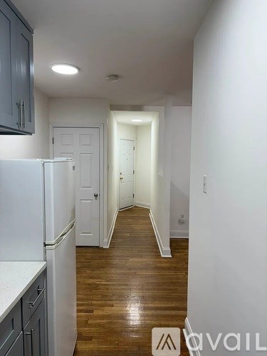 A kitchen with a refrigerator and cabinets.