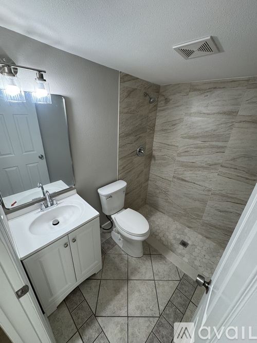 A bathroom with a toilet, sink, and shower.