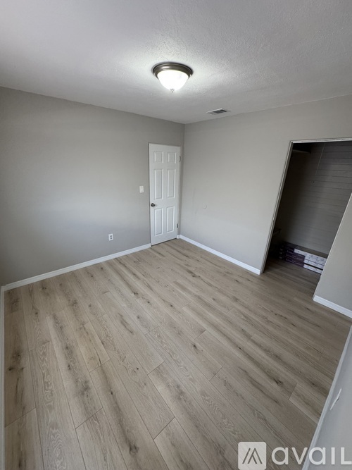 A room with wooden flooring and a white door.