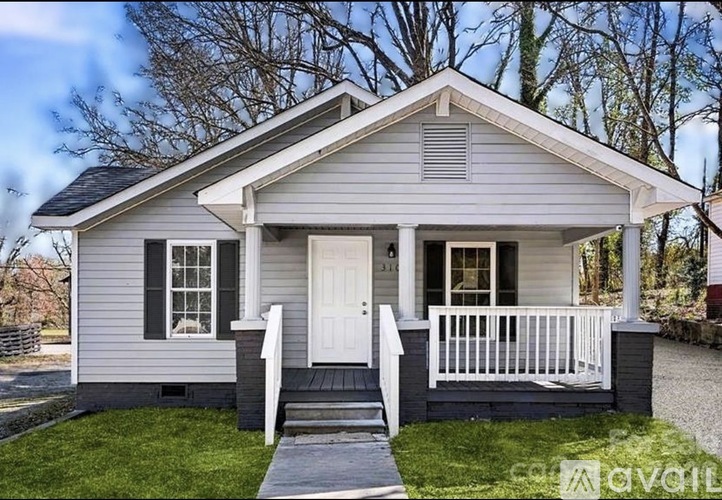 A small house with a white porch and a white door.