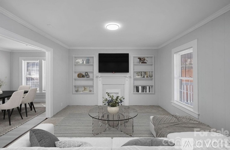A living room with a fireplace and a television on the wall.