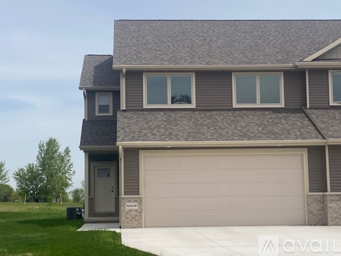 A house with a grey roof and a garage door.