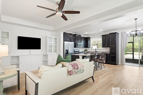 A living room with a white couch and a ceiling fan.