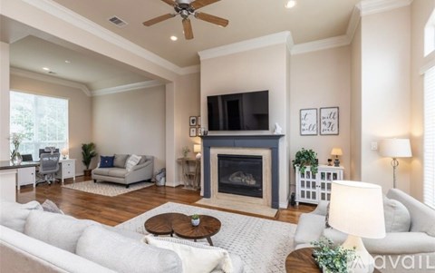 A living room with a fireplace and a television on the wall.