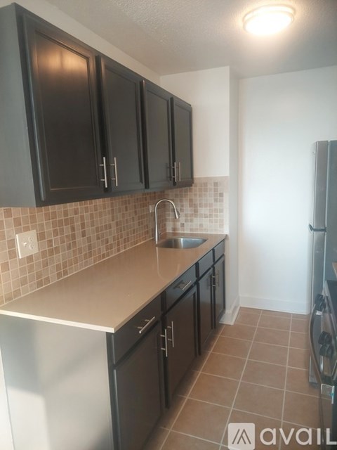 A kitchen with black cabinets and a white fridge.