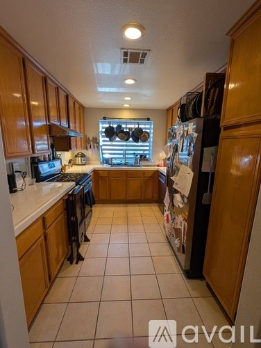 A kitchen with wooden cabinets and a refrigerator.