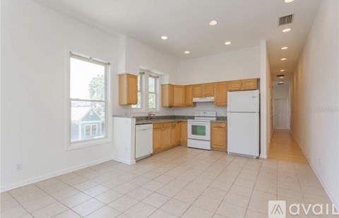 A kitchen with white appliances and wooden cabinets.