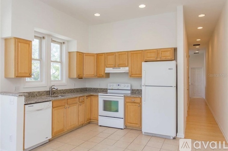 A kitchen with white appliances and wooden cabinets.