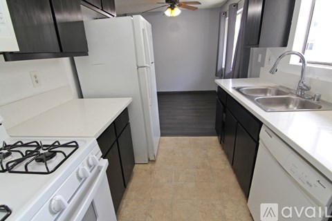 A kitchen with black cabinets and white appliances.