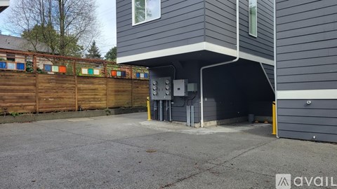 A grey building with a wooden fence and a garage door.