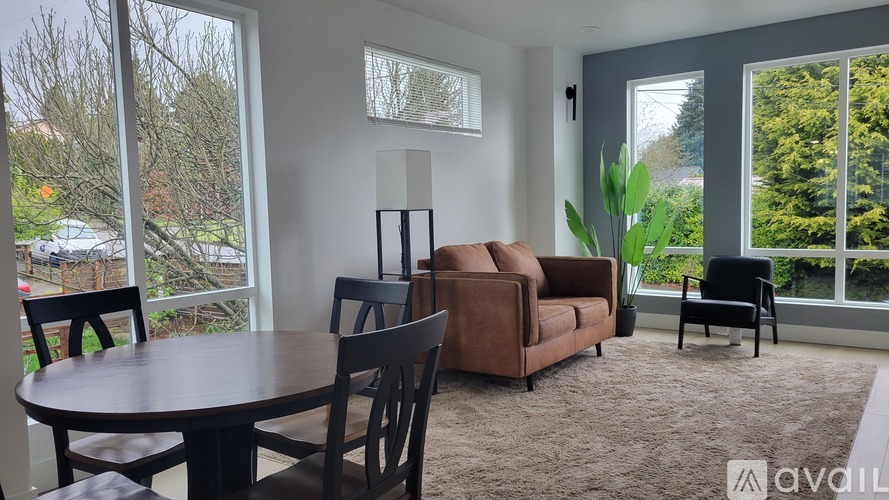 A living room with a brown couch, a brown chair, and a brown table.