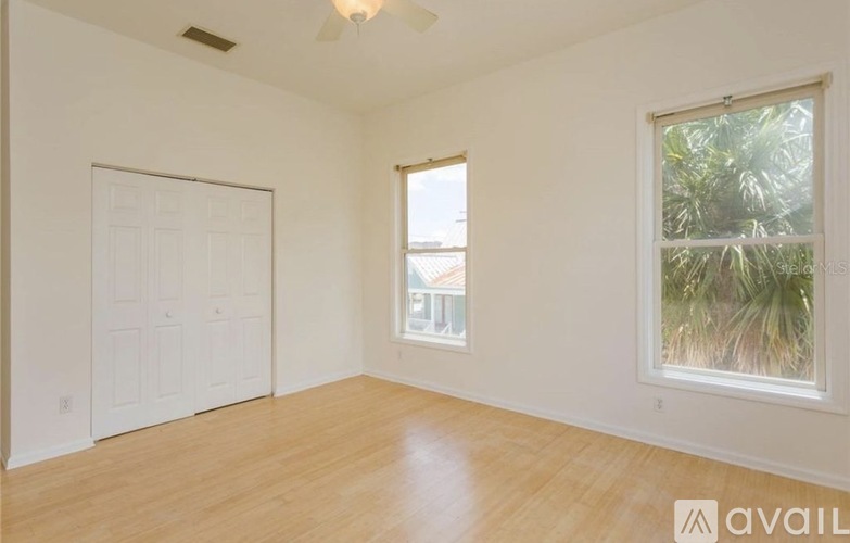 A room with a white door, a window, and a ceiling fan.