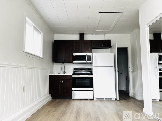 A kitchen with white appliances and wooden cabinets.