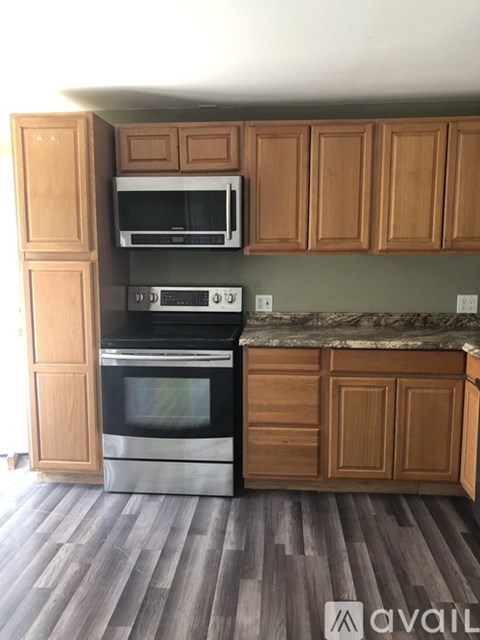A kitchen with wooden cabinets and a black oven.