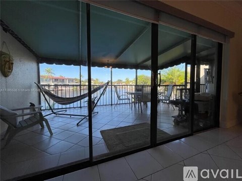 A patio with a hammock and chairs is visible through the sliding glass doors.