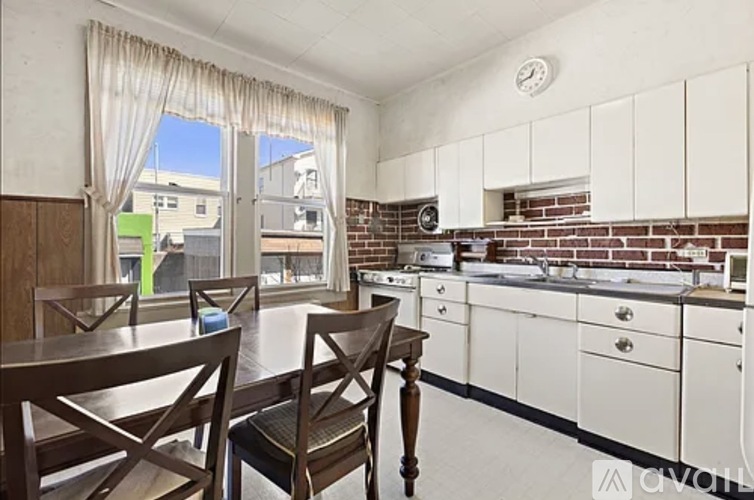 A kitchen with white cabinets and a brick backsplash.