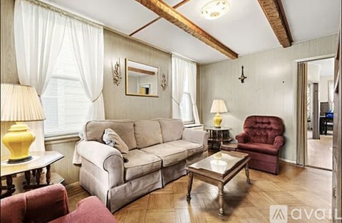 A living room with a grey couch, a red chair, and a coffee table.