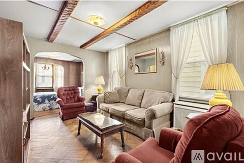 A living room with a red chair and a grey couch.