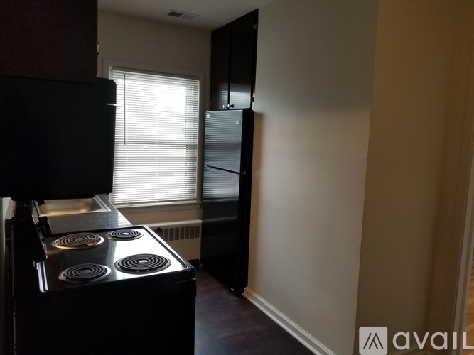 A black stove in a kitchen with a window and a wall-mounted oven.