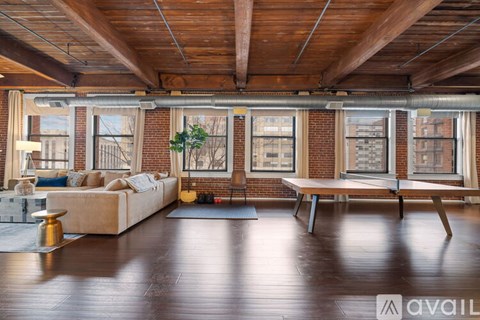 A living room with a couch, a coffee table, and a large window.