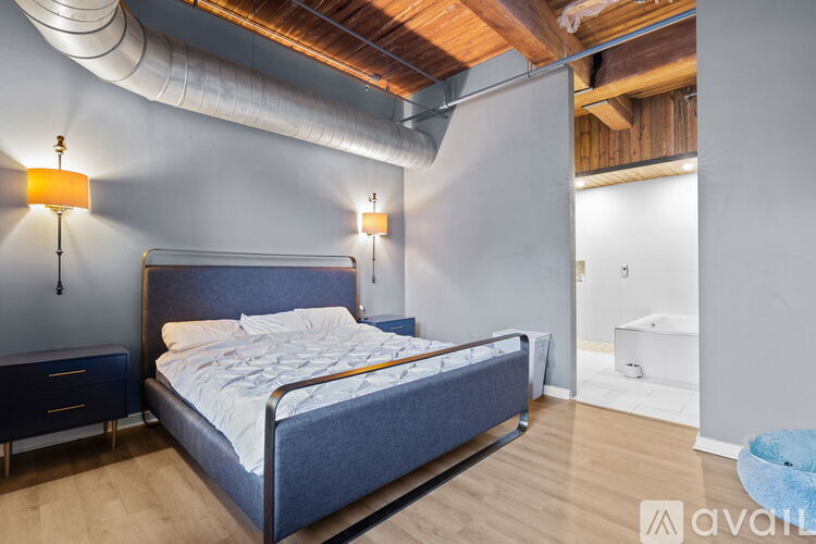 A bedroom with a large bed and a wooden ceiling.