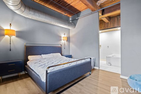 A bedroom with a large bed and a wooden ceiling.