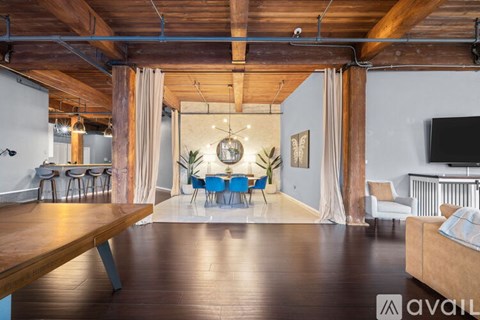 A spacious room with wooden floors and a long table set for a meal.