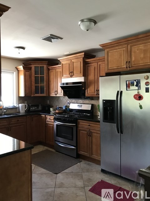 A kitchen with wooden cabinets and a stainless steel refrigerator.