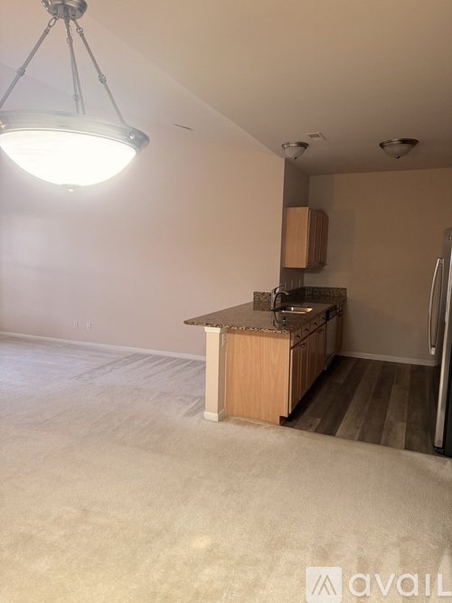 A kitchen area with a wooden island and a refrigerator.