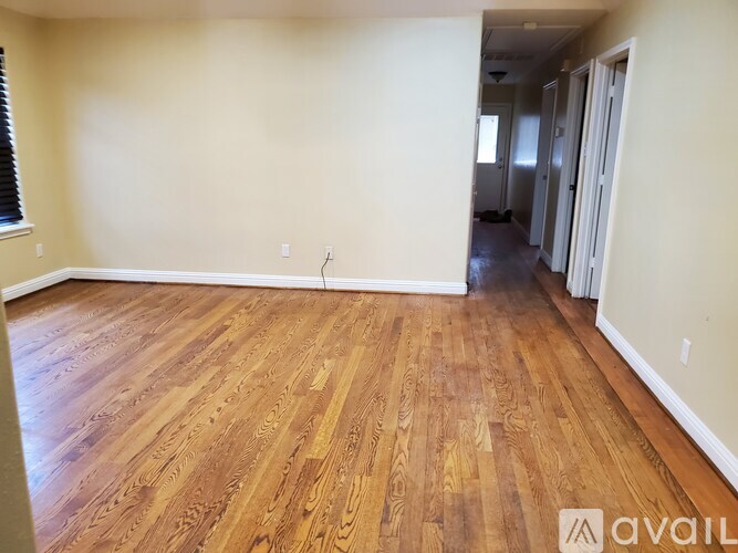 A room with wooden flooring and white walls is available for rent.
