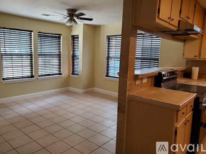 A kitchen with a fan on the ceiling and a countertop with a sink.