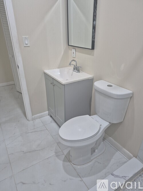 A white toilet sits next to a sink in a bathroom.