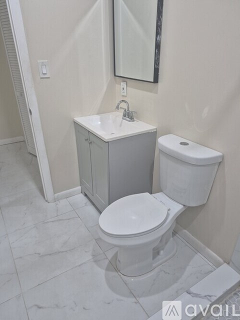 A white toilet sits next to a sink in a bathroom.