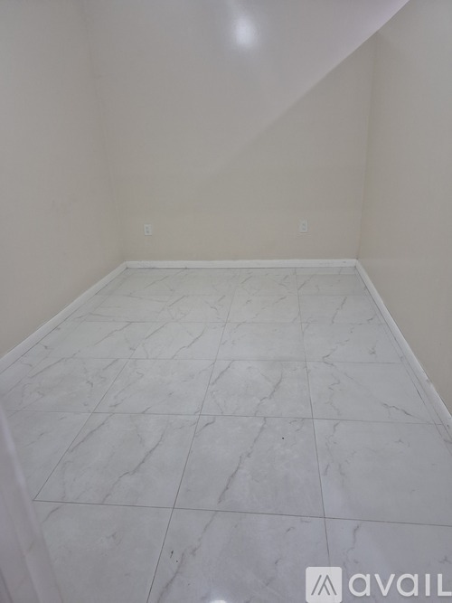 A room with white marble tiles on the floor.