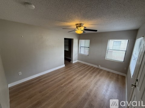 A room with a ceiling fan and wooden flooring.