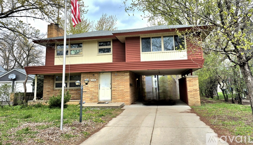 A house with a flag on the front lawn.