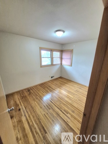 A room with wooden flooring and a window.