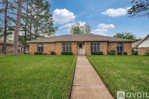 A brick house with a green lawn in front.