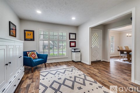A living room with a blue couch and a rug.
