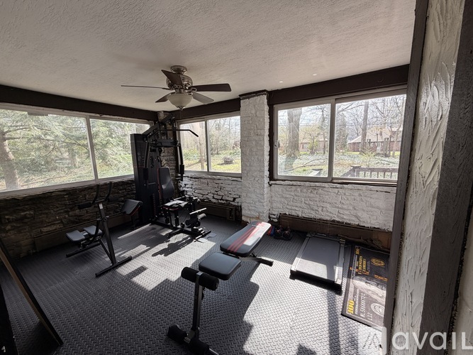 A home gym with a variety of equipment including a treadmill, weights, and a bench press.